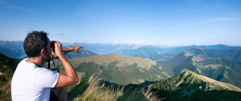 Mann schaut durch Feldstecher Uomo che guarda con il binocolo